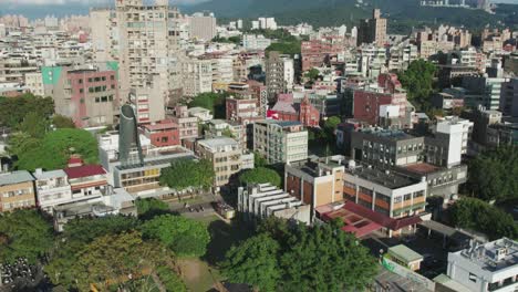 Aerial-parallax-shot-of-Tamsui-City-covered-with-greenery-in-a-sunny-afternoon-in-Taiwan