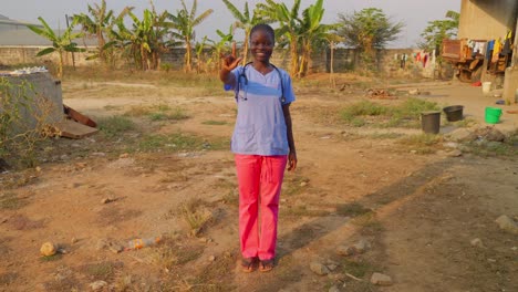 portrait-of-nurse-african-black-doctor-saying-I-love-you-with-hands-gesture-language-in-remote-rural-village