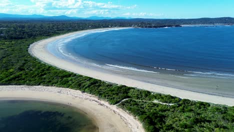 Drone-aerial-landscape-white-sands-bay-ocean-waves-coastline-bushland-Broulee-beach-Mossy-Point-Tomakin-South-Coast-Australia