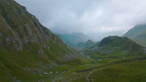 Bergluftaufnahme-Mit-Nebligen-Wolken-Und-Kleinem-Fluss-In-Den-Alpen,-Frankreich