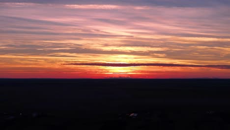 Ein-Faszinierender-Sonnenuntergang-über-Einem-Malerischen-Dorf-In-Schwarz--Und-Orangetönen