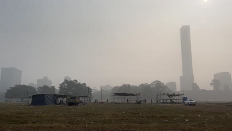 Brigade-Maidan-Gelände-An-Einem-Nebligen-Wintermorgen-Mit-Einigen-Ständen-Und-Fahrzeugen-Darauf-In-Kalkutta,-Indien