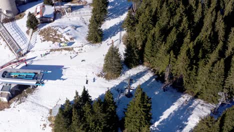 Aerial-view-of-people-skiing-in-a-winter-resort-at-the-foot-of-a-lift