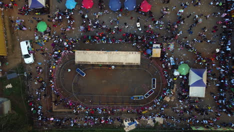 Aerial-view-over-people-and-rides-at-a-fair-in-cloudy-Yaounde,-Cameroon,-Africa