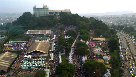 Aerial-view-backwards-over-a-fair-at-the-Yaoundé-Conférence-Centre,-in-Cameroon