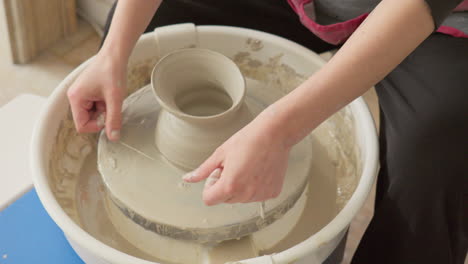 Der-Keramikkünstler-Vollendet-Meisterhaft-Eine-Vase-Auf-Einer-Töpferscheibe,-Indem-Er-Sie-Mithilfe-Von-Draht-Abnimmt