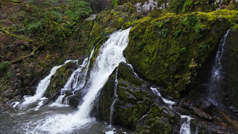4K-drone-footage-side-view-of-waterfall-in-forest-covered-with-moss-rocks-in-the-pacific-northwest-America