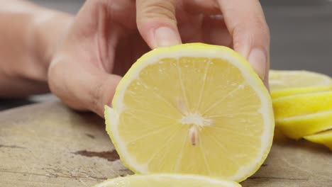 Cutting-a-piece-of-lemon-on-board-with-a-large-knife