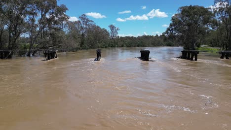 Drone-of-flooded-Goulburn-river-with-fast-waters-passing-an-old-bridge