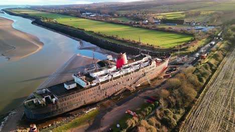 Ghost-Ship-the-Duke-of-Lancaster-at-sunset---drone-anti-clockwise-rotate-and-pull-back,-reveal-bay---Mostyn,-North-Wales,-UK