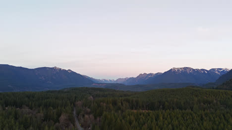 4K-drone-footage-during-sunset-overlooking-cascade-mountains-flying-over-evergreen-forest-in-the-pacific-northwest