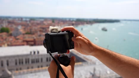 Male-hands-operate-compact-camera-to-make-video-from-Campanile-viewpoint