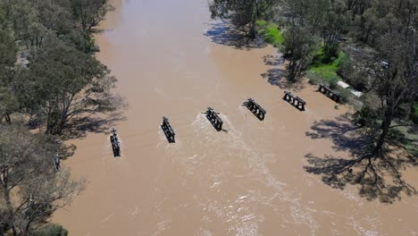 Hohe-Drohnenaufnahme-Des-überfluteten-Flusses-Goulburn-Mit-Schlammigem-Wasser-Und-Von-Bäumen-Gesäumten-Ufern