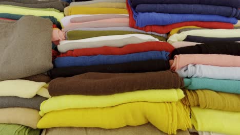 Various-colorful-fabrics-lie-side-by-side-for-sale-on-a-table-in-a-market