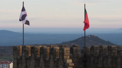 Close-up-of-Castelo-Branco-castle’s-flags-with-the-city-in-the-background