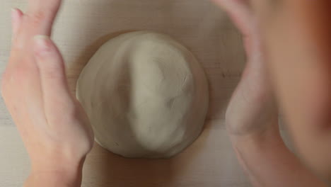 Skilled-artist-preparing-clay-with-her-hands-for-working-on-throwing-wheel