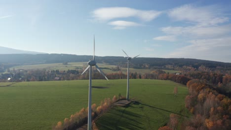 Wind-power-stations-on-sunny-day-near-village-surrounded-by-meadow