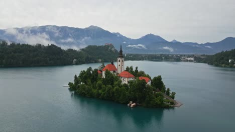Swing-out-drone-shot-of-Lake-Bled,-Slovenia-in-the-morning-during-summer-time