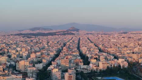 Aerial-of-Athens-capital-city-of-Greece,-drone-above-scenic-cityscape-at-sunset