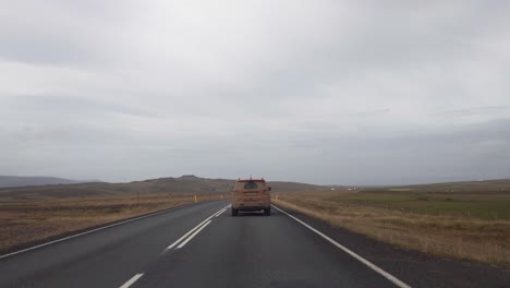 POV-driving-behind-a-dirty-4x4-car-after-a-rough-and-wet-gravel-road-in-the-mountains-of-Iceland