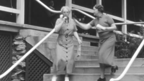 Las-Mujeres-Sonríen-Mientras-Bajan-Las-Escaleras-De-Una-Casa-En-La-Ciudad-De-Nueva-York-En-La-Década-De-1930.