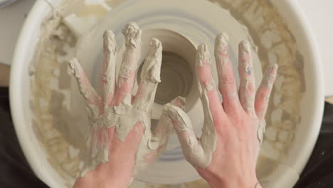 Pottery-artist-cleans-both-his-hands-of-sticky-clay-after-finishing-craft-work