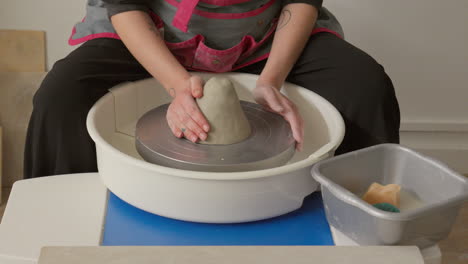 Skilled-artist-puts-on-a-piece-of-clay-on-a-throwing-wheel