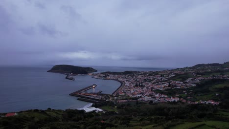 Aerial-footage-of-dusk-in-Horta,-showing-the-city-and-its-old-Monte-da-Guia-volcano