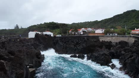 Aerial-footage-approaching-Varadouro-natural-pool-volcanic-rocks,-Faial,-Azores