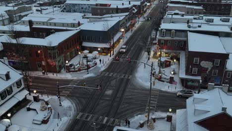 Dämmerung-über-Einer-Schneebedeckten-Kleinstadtkreuzung-Mit-Festlichen-Lichtern-Und-Einer-Ruhigen,-Winterlichen-Atmosphäre
