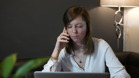 A-happy-young-professional-business-woman-working-at-home-talking-to-a-customer-or-colleague-on-the-phone