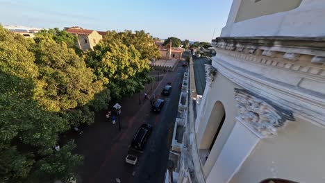 FPV-drone-flight-on-Street-in-Colonial-Zone-along-cathedral-at-sunset-time,-Dominican-Republic