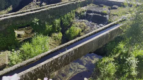 Alte-Historische-Wasserleitungen-Mit-Einem-Kleinen-Wasserfluss-Mit-Viel-Moos-Und-Wasserpflanzen