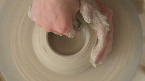 Ceramics-artist-making-a-bowl-on-a-potters-wheel-with-both-hands