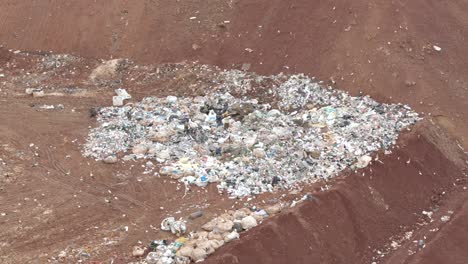 Aerial-4K-captures-a-waste-site's-rubble-where-numerous-birds-forage-for-food-amidst-locals-collecting-waste