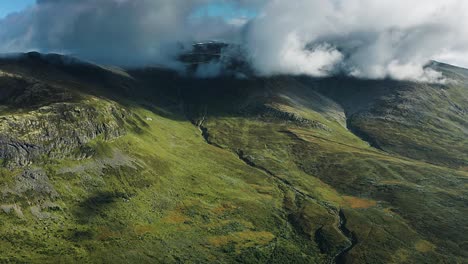 Toma-Panorámica-De-Vuelo-Rápido-De-Densas-Nubes-Blancas-Girando-Sobre-Las-Verdes-Colinas-Del-Aurlandsfjellet-Noruego