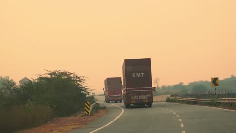 Camión-De-Carga-Con-Remolque-De-Carga-Conduciendo-Por-Una-Carretera-A-Través-De-Bosques-Y-Colinas-Durante-La-Mañana-En-La-India