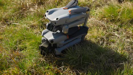 Stacked-Folded-DJI-Air-2S-And-Air-3-On-Grass-For-Side-By-Side-Comparison-Resting-On-Grass