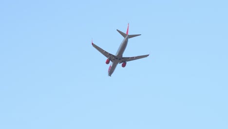 Jet2-Aircraft-with-blinking-lights-flying-away,-view-from-bellow
