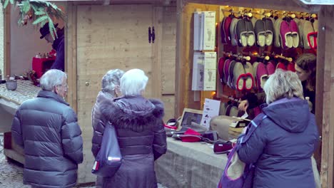 Female-customers-at-a-Christmas-market-stall-in-Klausen---Chiusa,-South-Tyrol,-Italy