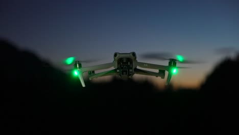 Hovering-DJi-Air-3-With-Green-Safety-Lights-At-Night-Time