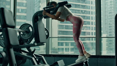 Girl-uses-Technogym-lever-squatting-machine-in-a-public-gym