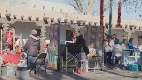 Tourists-shopping-from-street-vendors-in-downtown-Santa-Fe,-New-Mexico-with-stable-video-shot-panning-left-to-right