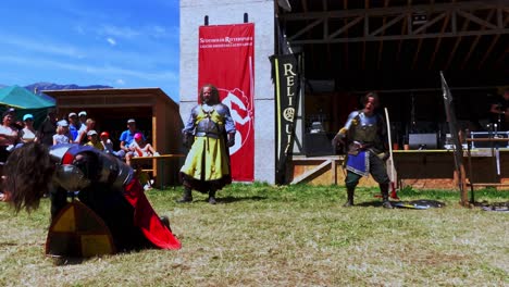 A-fighting-scene-with-sword-and-battle-axe-performed-by-Burdyri,-a-professional-sword-and-stage-combat-team,-during-the-South-Tyrolean-Medieval-Games-2023,-hand-held