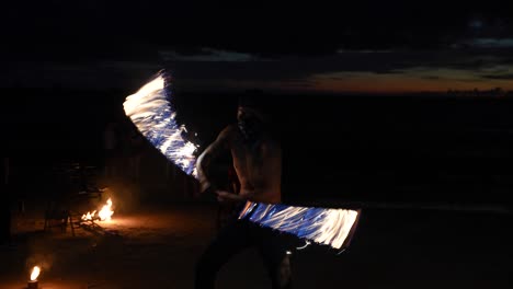 Un-Hombre-Realizando-Un-Espectáculo-De-Fuego-Por-La-Noche-En-La-Playa-De-Krabi,-Tailandia