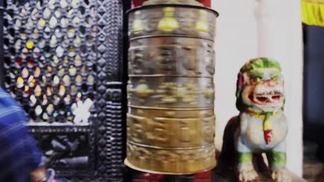 Frontal-view-of-Asian-locals-spinning-Buddhist-prayer-wheel-hoping-for-luck-and-prosperity,-static