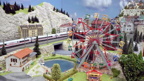Part-of-the-model-train-layout-with-ferris-wheel-at-the-25th-exhibition-of-model-trains-in-motion-in-Kaltern,-South-Tyrol,-Italy