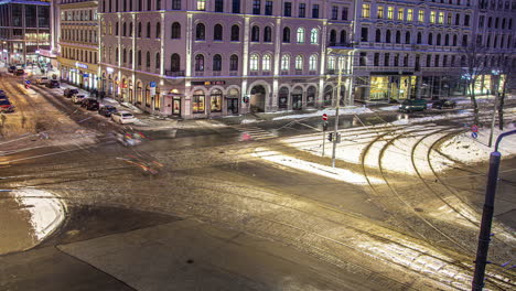 Timelapse-of-a-snowy-busy-street-intersection-at-night-in-Riga-Latvia