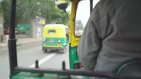 Aufnahme-Eines-Indisch-asiatischen-Mannes,-Der-Eine-Autorikscha-Oder-Ein-Tuk-Tuk-Durch-Die-Belebten-Straßen-Von-Delhi,-Indien,-Fährt