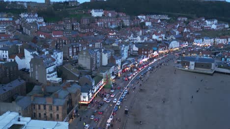 Aerial-drone-top-down-shot-over-busy-restaurants-along-the-beach-front-in-the-town-of-Scarborough,-North-Yorkshire,-England-during-evening-time